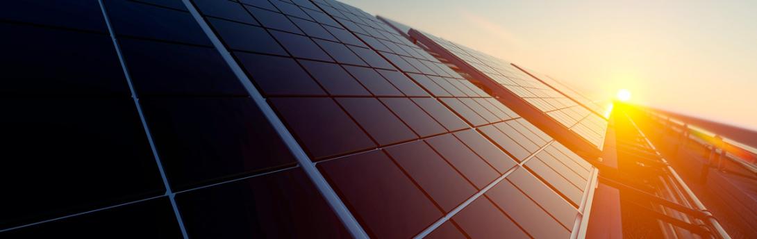 Sun rising over a close up of a solar panel