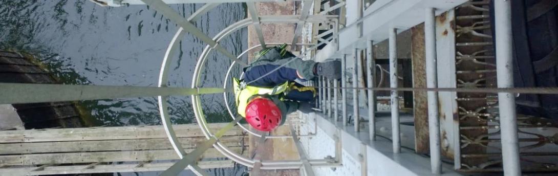 Employee climbs down a ladder to a water tank